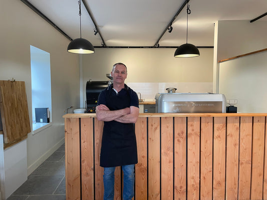 Photo of owner, Stevie, leaning against the roastery countertop
